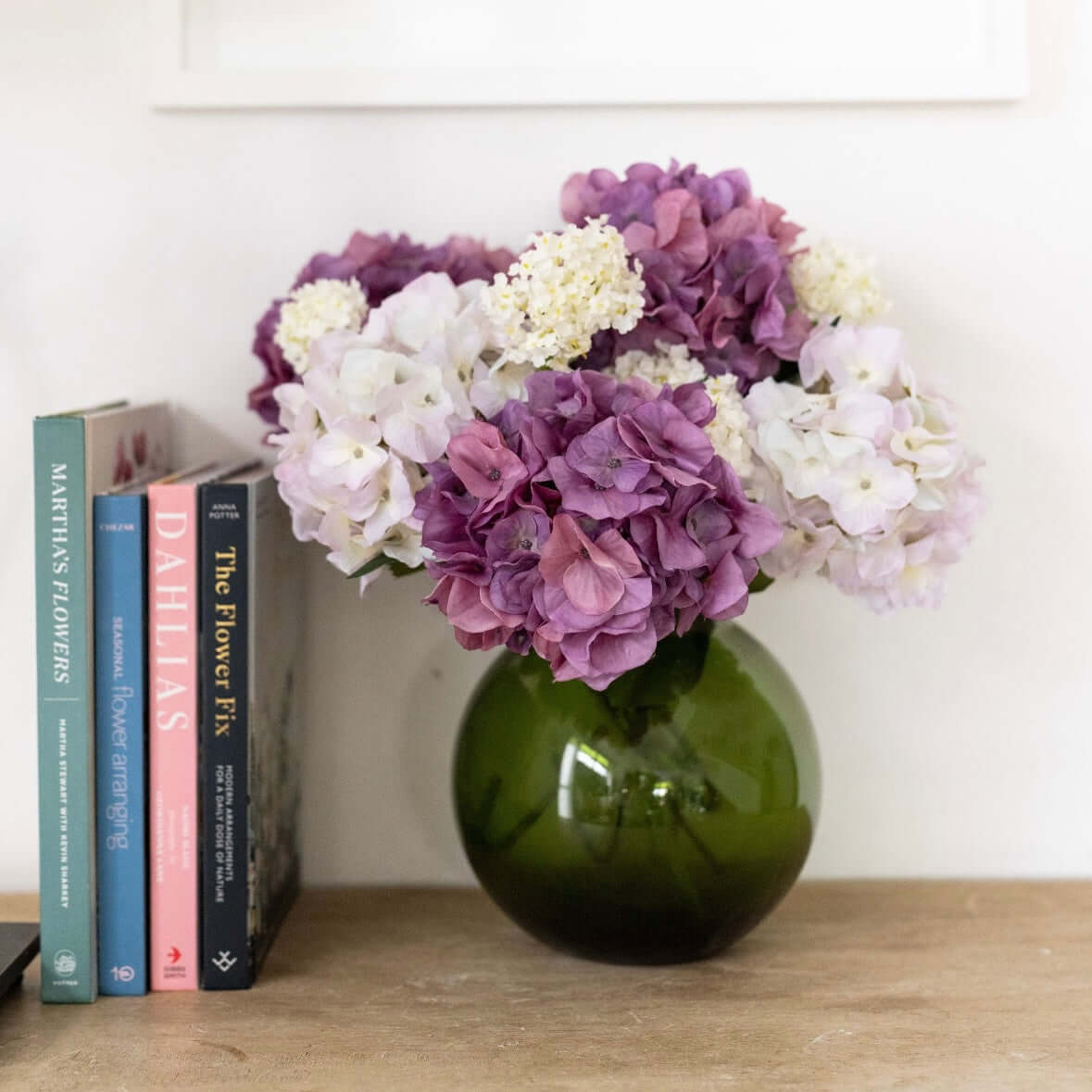 arrangement of purple flowers in glass vase