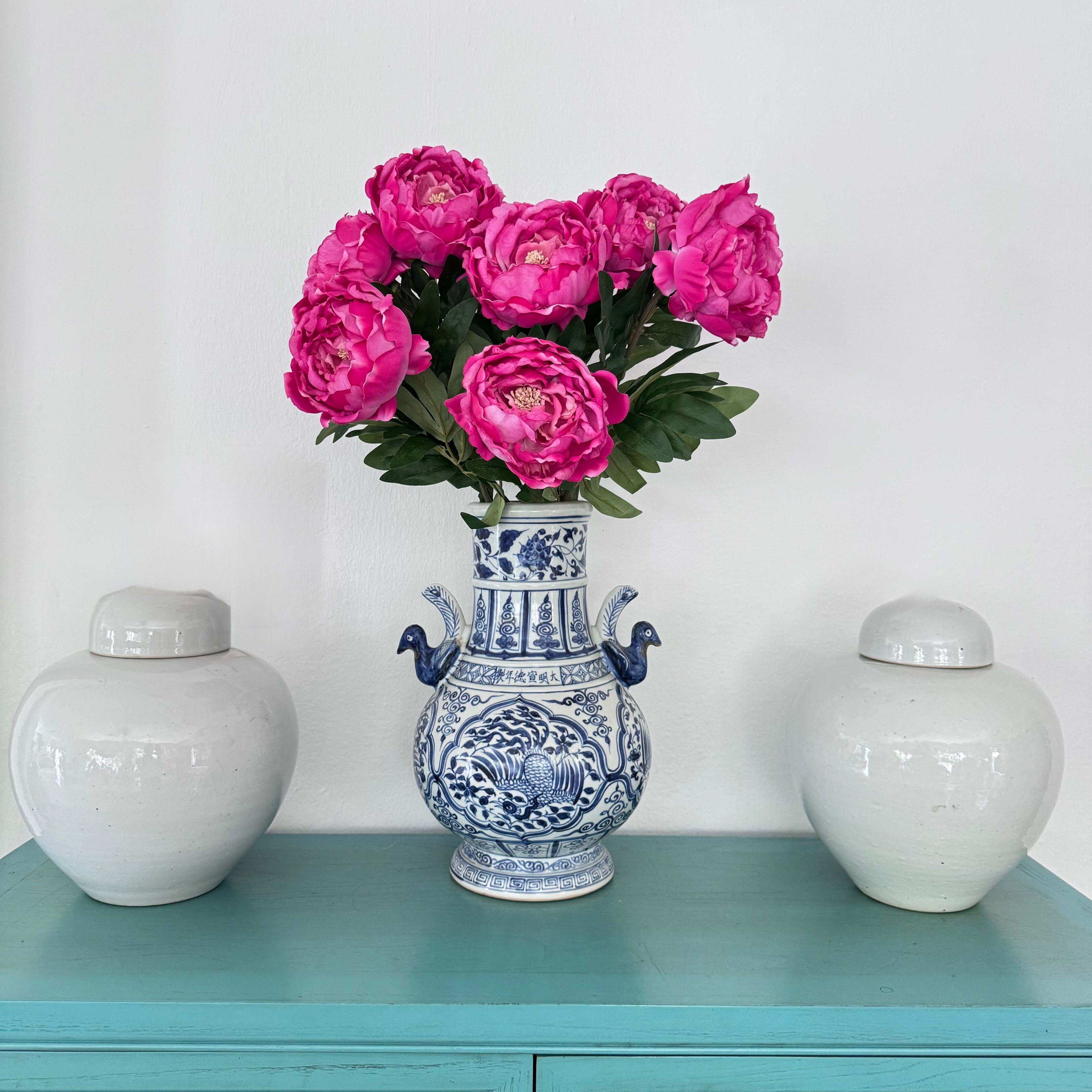 large arrangement of pink peonies in white and blue vase