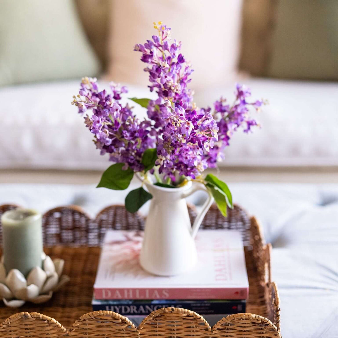 Artificial purple flowers in white jug