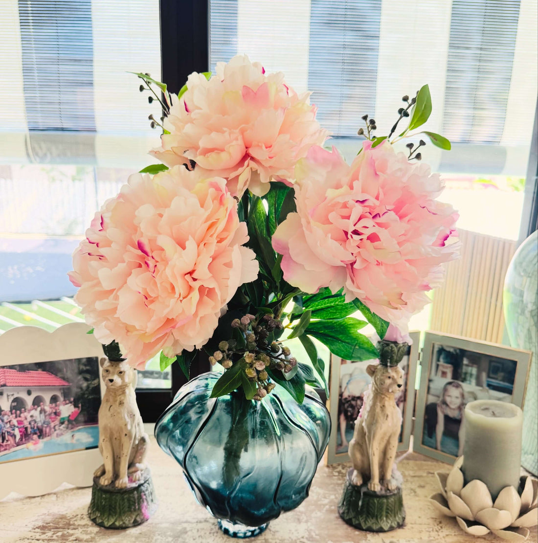 Pink artificial flowers in glass vase