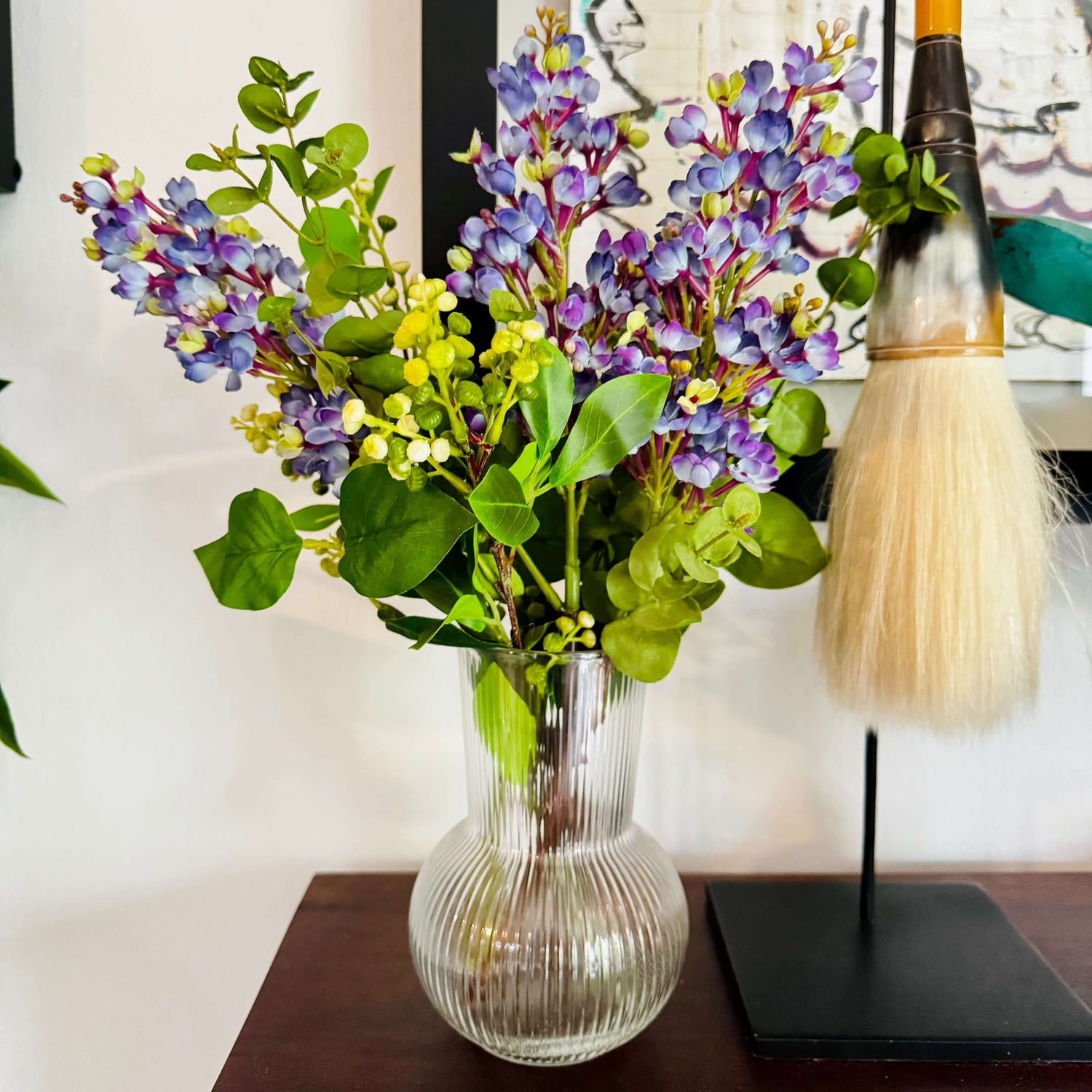 small bouquet of purple flowers in glass vase